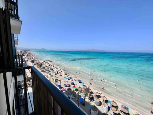 une vue sur une plage avec des parasols et l'océan dans l'établissement Apartamento Alborada Villas2meet Mallorca, à Can Picafort