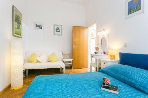 a bedroom with a blue bed and a desk at Apartments Adriana Flora in Dubrovnik