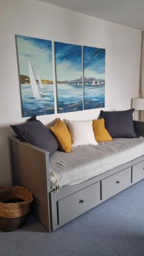 Bett in einem Zimmer mit vier Fenstern in der Unterkunft Ferien Appartment Panoramica mit Seeblick in Überlingen