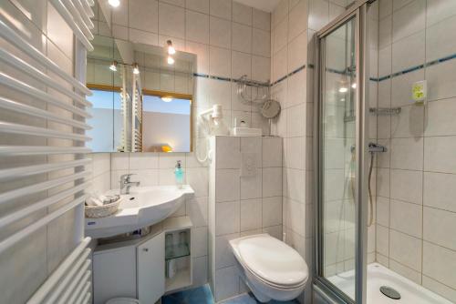 uma casa de banho com um WC, um lavatório e um chuveiro em Waldhotel Humboldt em Salzhemmendorf