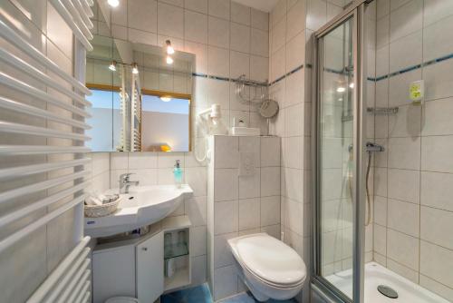 a bathroom with a toilet and a sink and a shower at Waldhotel Humboldtsee in Salzhemmendorf
