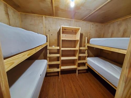 a small room with two bunk beds and wooden floors at Baffin Bay Penthouse in Corpus Christi