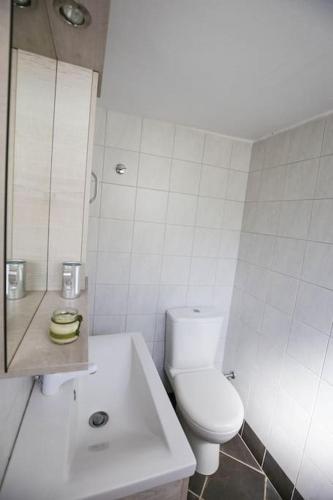 a white bathroom with a toilet and a sink at The cozy nest:) in Batsi