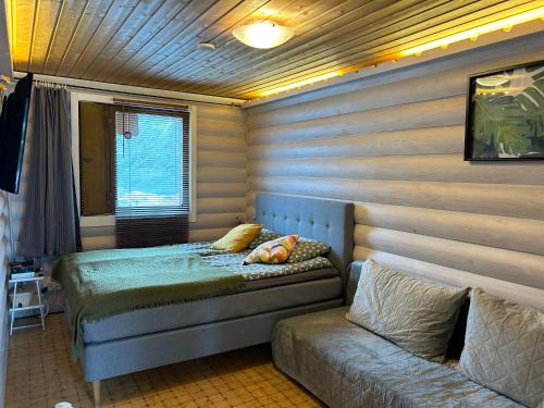 a bedroom with two beds and a couch in it at Vantaa Sauna Cottage in Vantaa