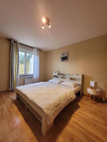 une chambre avec un grand lit et une fenêtre dans l'établissement Appartement cosy dans beau village de Champagne, à Cormicy