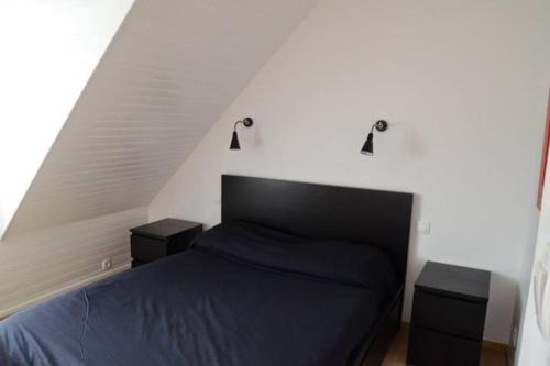 Un dormitorio con una cama y dos mesitas de noche. en Maison dans son écrin de verdure, en Plouvien