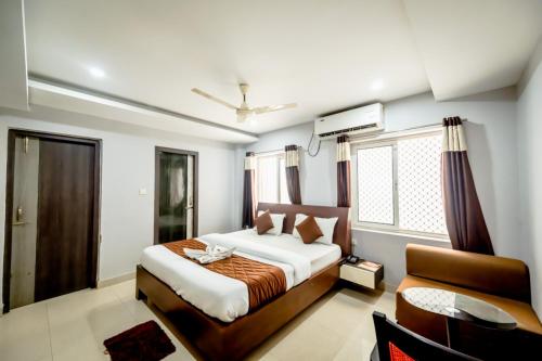 a bedroom with a bed and a chair in it at Goroomgo Hotel Shivangi Puri Near Sea Beach in Puri