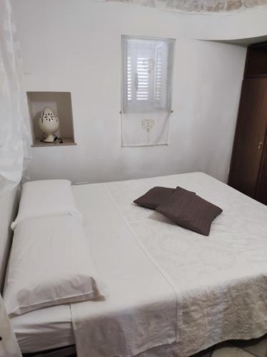 um quarto com uma cama branca e uma almofada em U Casied em Montalbano