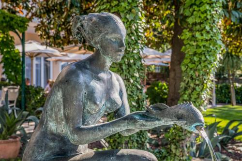 a statue of a woman feeding a bird at Hotel Marko in Portorož