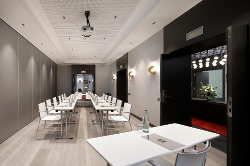 a conference room with white tables and white chairs at Olivia Plaza Hotel in Barcelona