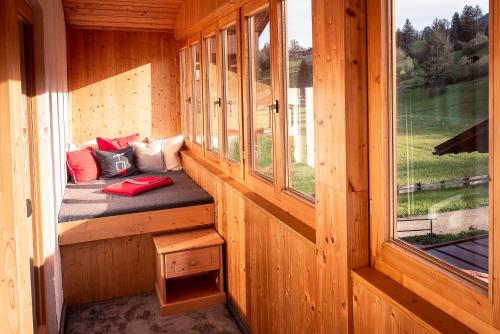 a bench in a wooden cabin with a window at Ferienwohnungen Scheibenhaus in Oberstdorf