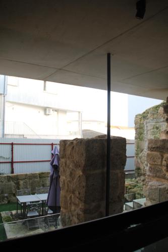 a stone wall with a table and a tent at Bemyguest - Loft Guest House Jardim das Mães Charming in Viseu