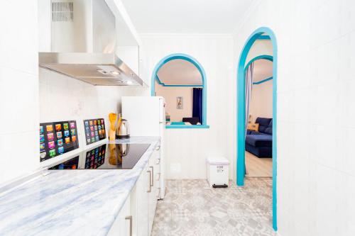 トレビエハにあるALEGRIA ED. LOS GASESのキッチン(白いカウンター、青いアーチ型の窓付)