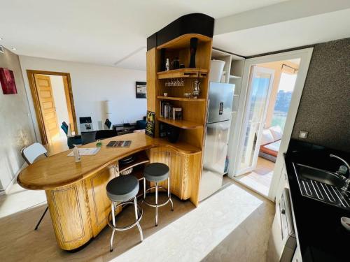 eine Küche mit einem Holztisch und eine Küche mit einem Kühlschrank in der Unterkunft Bouznika, Seaside Escape - Surf, Relaxation, Pools - at StayInMoroccoVibes in Bouznika