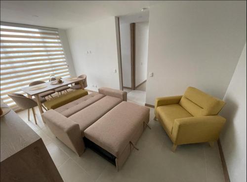 a living room with a couch and chairs and a table at Apartamento nuevo Manizales. in Manizales