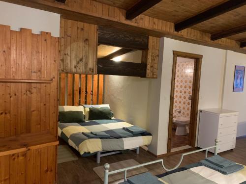 um quarto com uma cama num quarto com paredes de madeira em Bielmonte Appartamenti em Bielmonte