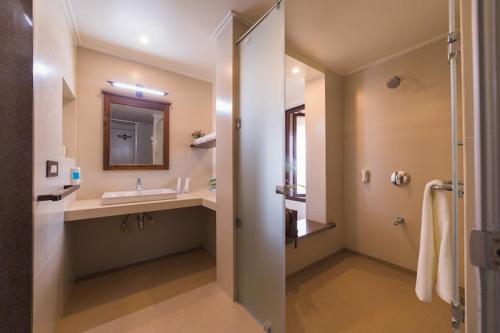 a bathroom with a sink and a mirror and a shower at Riverside County Resort in Chandoli