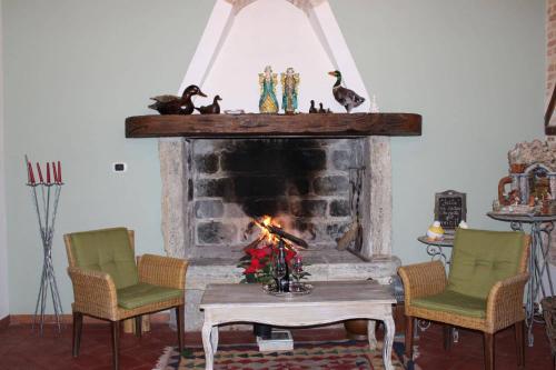 sala de estar con chimenea, sillas y mesa en Antica Cantina Emilia en Reggio Calabria