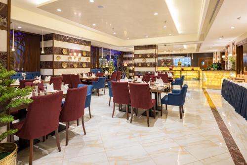 a restaurant with tables and chairs in a room at Elite Park Hotel in Jeddah