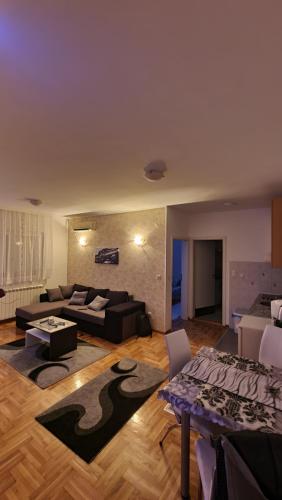 un soggiorno con divano e tavolo di Apartman Nikola a Žarkovo