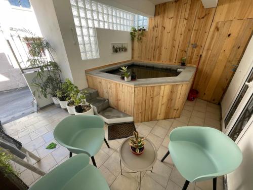 bañera de hidromasaje en una habitación con sillas verdes en Sam & Chlo Studio & Appartment - Grand Baie - Mauritius, en Grand Baie