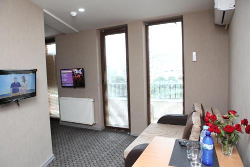 a living room with a couch and a table with flowers at Hotel Voyager in Tbilisi City