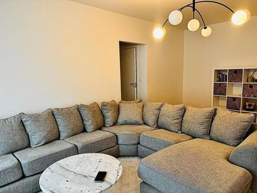 un grande divano in un soggiorno con tavolo di Lejlighed centrum af Helsingborg a Helsingborg