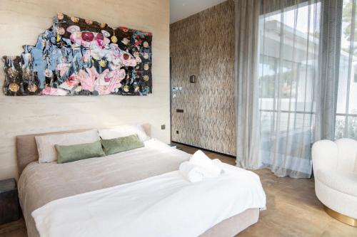- une chambre avec un lit et une peinture murale dans l'établissement Villa Lujo Castelldefels Barcelona, à Castelldefels