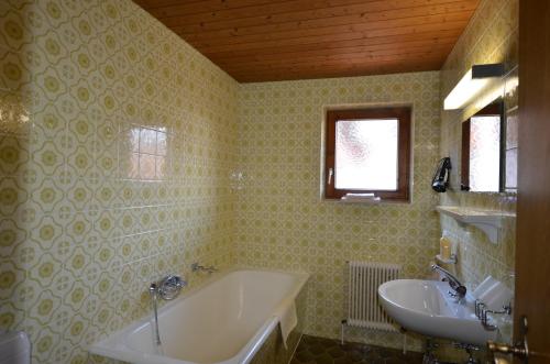 ein Badezimmer mit einer Badewanne und einem Waschbecken in der Unterkunft Haus Monika und Haus Claudia in Mayrhofen