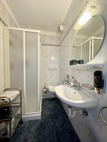 a white bathroom with a sink and a shower at Hotel Residence MaVie in Lagundo