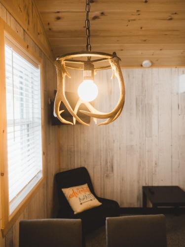 a chandelier in a room with a chair and a table at Mini-Chalet - Abenaki Aventure in Pierreville