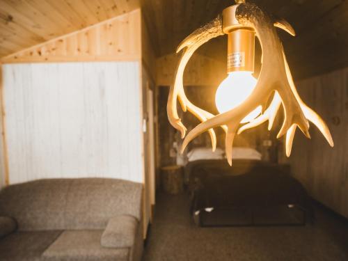 a chandelier in a room with a couch and a bed at Mini-Chalet - Abenaki Aventure in Pierreville