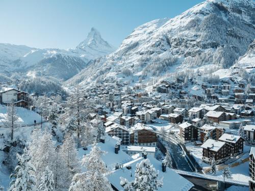 eine schneebedeckte Stadt mit einem Berg im Hintergrund in der Unterkunft Petit Chalet by Schönegg in Zermatt