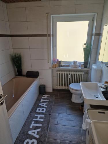 a bathroom with a tub and a toilet and a sink at Berger´s Apartment-Hotel in Grafenwöhr