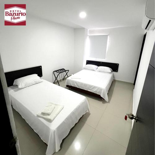 een kamer met twee bedden en een bord aan de muur bij Hotel bazurto plaza in Cartagena