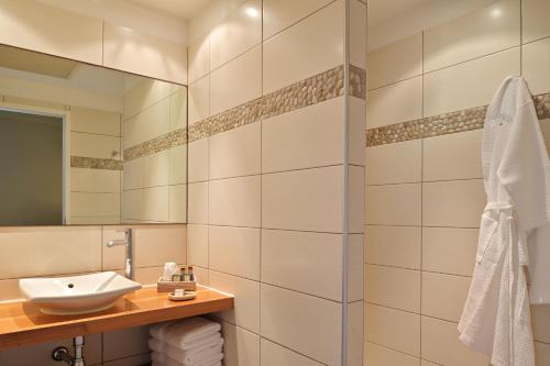 een badkamer met een wastafel en een spiegel bij Hôtel Abbartello in Olmeto