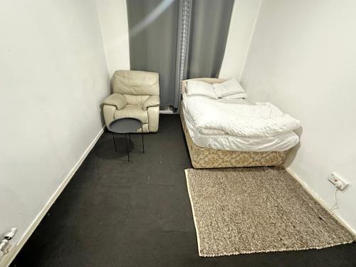 a small room with two beds and a chair at Private room in Glasgow City centre in Glasgow