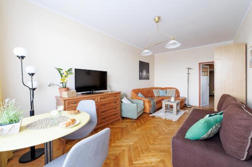 a living room with a couch and a tv at Apartament 2 pokoje w Gdańsku blisko morza 1000 m do plaży in Gdańsk