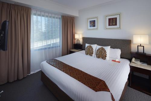 a hotel room with a large bed and a window at Pagoda Resort & Spa in Perth