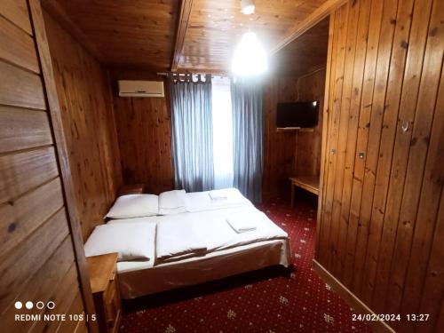 a bedroom with a bed in a wooden room at Green House in Wola Przypkowska