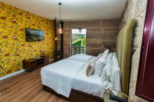 a bedroom with a white bed with yellow walls at Ecocasa Lema II in Muxia