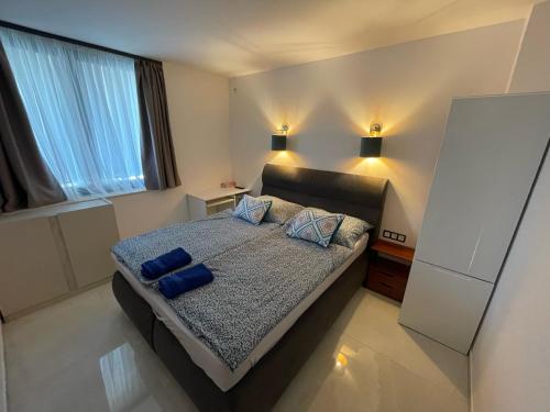 a bedroom with a bed with two blue pillows on it at Luxury Apartments in Balatonalmádi, Almádi Lux Apartman I - Ocean Blue in Balatonalmádi