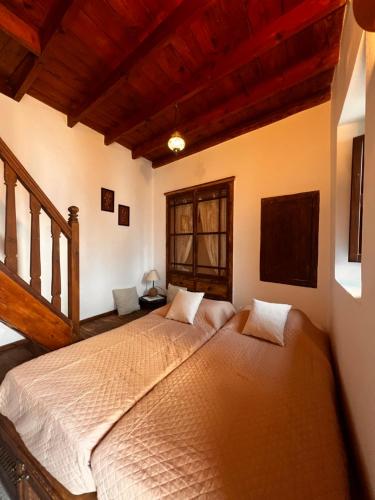 a bedroom with two beds in a room with wooden ceilings at Elegant-Lindian Villa Marietta in Líndos