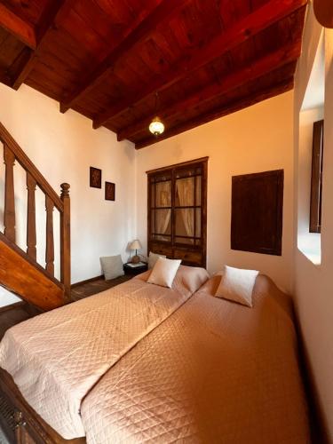 a bedroom with two beds in a room with wooden ceilings at Elegant-Lindian Villa Marietta in Lindos