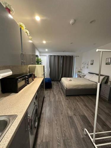 a kitchen with a bed and a sink in a room at cozy studio in Raynes Park House in Raynes Park