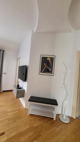 - un salon avec un banc et une télévision dans l'établissement San Siro Terrace Attic Apartment Milano, à Milan