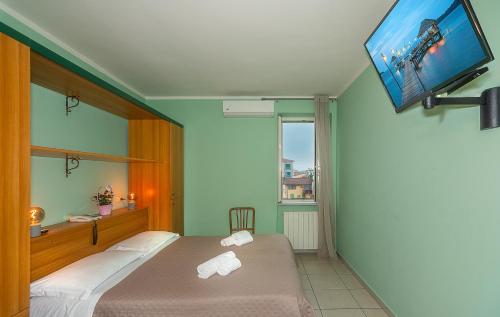 a bedroom with a bed and a flat screen tv at Hotel Villa Benvenuti in Viareggio