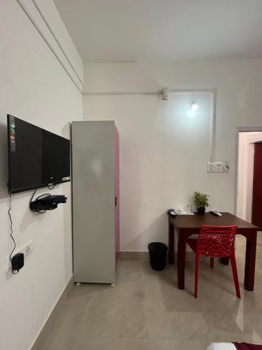 um quarto com uma mesa e uma televisão na parede em USC Home Stay-304 em Guwahati