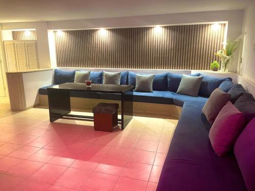ein Wohnzimmer mit einem blauen Sofa und einem Tisch in der Unterkunft Elegant Relaxing Oasis in the Heart of Sfax in Sfax