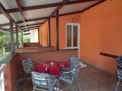 een tafel en stoelen in een kamer met oranje muren bij Sobe Viktorija in Veliko Gradište